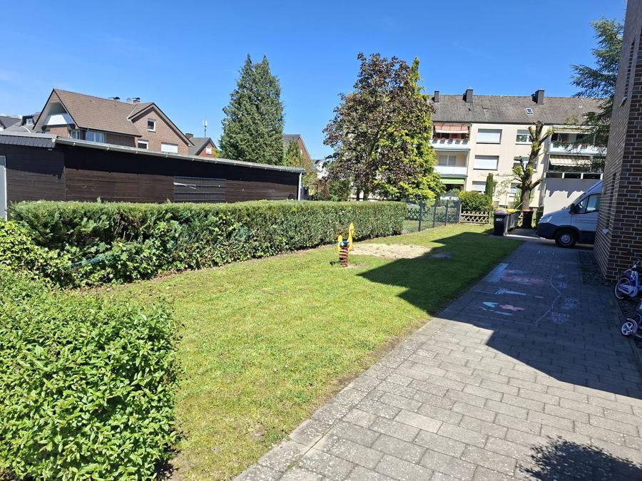 Gepflegter Innenhof mit Rasen und geschnittenen Hecken